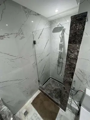a bathroom with a shower with a marble wall at Appartement Palace B in Marrakech