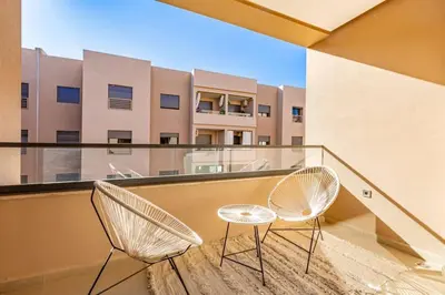 two chairs on a balcony with a building at New! Appt Spacieux et Lumineux à Menara Garden in Marrakech
