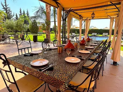 a long table with chairs and plates on it at Palais Ona in Marrakech