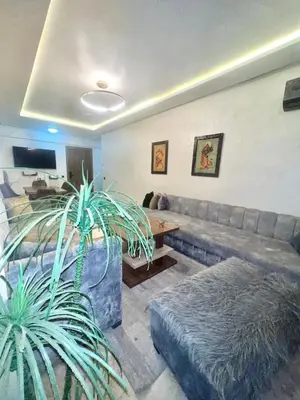 a living room with a couch and a table at Bel Appartement nour 5 in Marrakech
