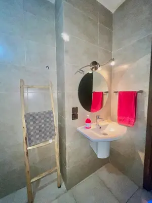 a bathroom with a sink and a mirror at Bel Appartement nour 5 in Marrakech