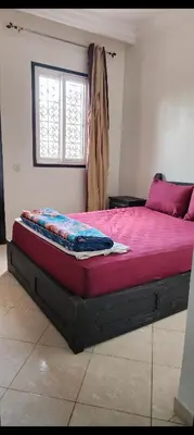 a large bed in a room with a window at Apparemment a Marrakech très agr in Marrakech