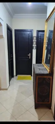 a room with two black doors and a mirror at Apparemment a Marrakech très agr in Marrakech
