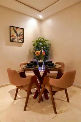 a dining room with a table with chairs and flowers at Appartement 2 chambres perle 24 in Marrakech