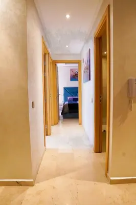 a hallway with a hallway leading to a bedroom with a bed at Appartement 2 chambres perle 24 in Marrakech