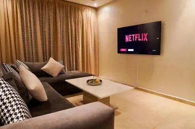 a living room with a couch and a tv on the wall at Appartement 2 chambres perle 24 in Marrakech