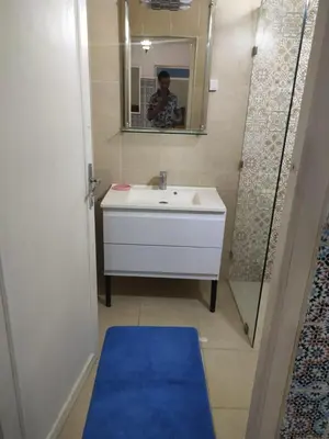 a man taking a picture of a bathroom with a sink at Appartement de luxe in Marrakech