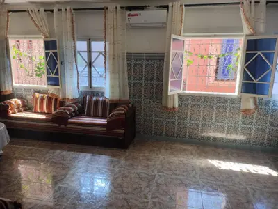 a living room with a couch and windows at Appartement de luxe in Marrakech