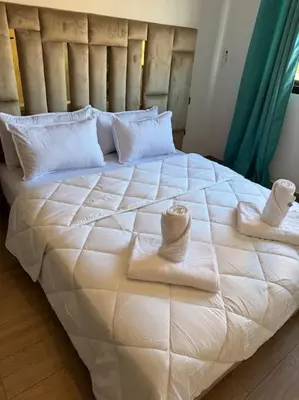 a large white bed with towels and pillows on it at Appartement à Gueliz près de toute commodité in Marrakech
