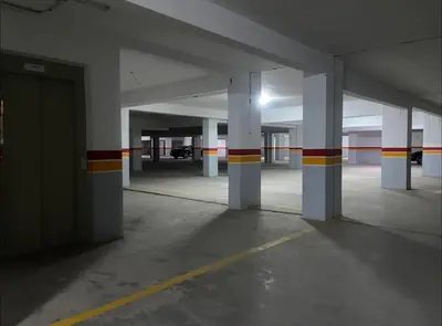 an empty parking garage with white columns and red and yellow stripes at Appartement à Gueliz près de toute commodité in Marrakech