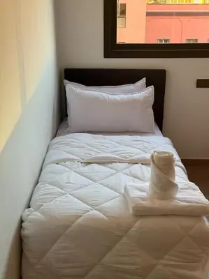 a white bed with a hat on top of it at Appartement au centre de gueliz in Marrakech