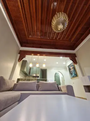 a living room with a couch and a chandelier at les jardins de la palmeraie 2 appart in Marrakech