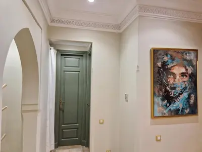a painting on the wall next to a green door at les jardins de la palmeraie 2 appart in Marrakech