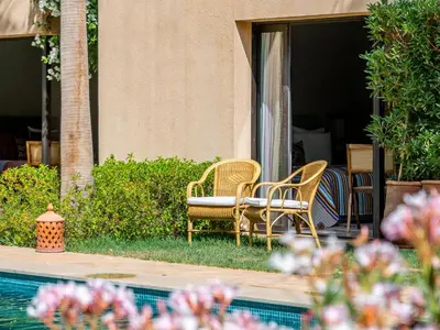 two chairs and a table next to a pool at Villa Albatros in Marrakech