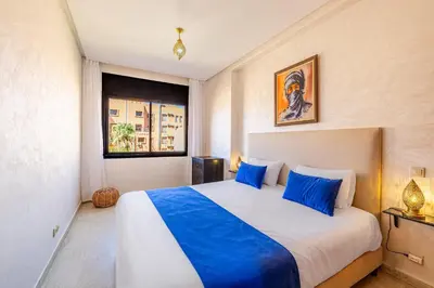 a bedroom with a large bed with blue pillows at Appartement Marrakech - quartier Gueliz in Marrakech