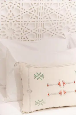a white pillow on a bed with a snowflake wallpaper at Dar Coco 180 in Marrakech