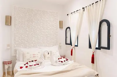 a bedroom with two beds with red and white pillows at Dar Coco 180 in Marrakech