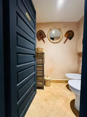 a bathroom with a black door and a toilet and a sink at Dar Coco 180 in Marrakech