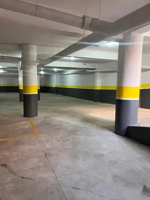 an empty parking garage with yellow and blue columns at La rose à côté Carry in Marrakech