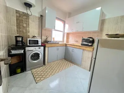 a kitchen with a washing machine and a microwave at La rose à côté Carry in Marrakech