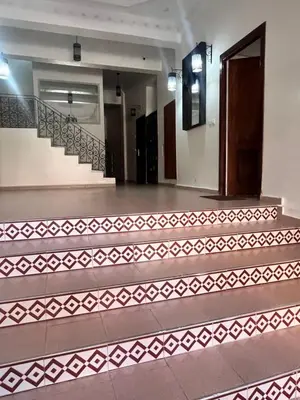 an empty lobby with stairs and a door at La rose à côté Carry in Marrakech
