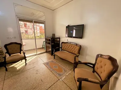 a living room with two chairs and a flat screen tv at appartement au coeur de marrakech proche de tout in Marrakech