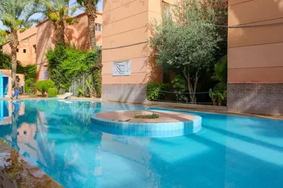 a swimming pool with blue water in a building at Riad Norakech nah zu allen Touristen-Attraktionenr in Marrakech