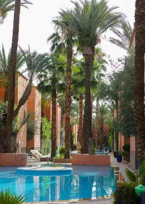 a resort with palm trees and a swimming pool at Riad Norakech nah zu allen Touristen-Attraktionenr in Marrakech