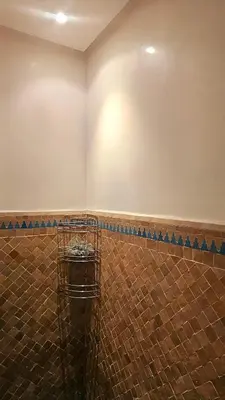 a bathroom with a wall and a basket in the corner at Beautiful cozy apartment with pool in Marrakech