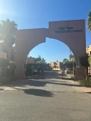 an entrance to a parking lot with a gate at Beautiful cozy apartment with pool in Marrakech