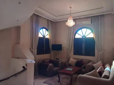 a living room with a couch and two windows at Villa Lmima Malika in Marrakech