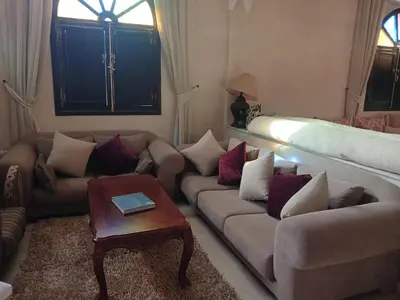a living room with two couches and a table at Villa Lmima Malika in Marrakech