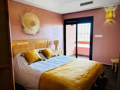 a bedroom with a large bed with orange walls at Jardin Majorelle Appartement in Marrakech