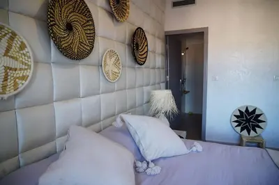 a bedroom with a purple bed with pillows and a wall at Jardin Majorelle Appartement in Marrakech