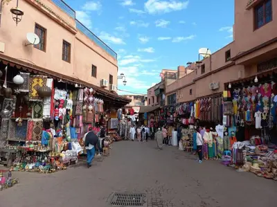 a group of people walking through a market with shops at Jardin Majorelle Appartement in Marrakech