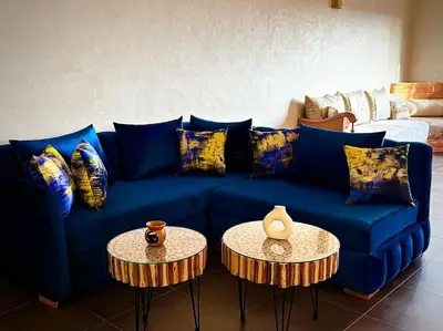 a blue couch with two tables in a living room at Jardin Majorelle Appartement in Marrakech