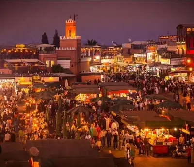 a crowd of people walking around a market at night at Appartement Haut standing in Marrakech