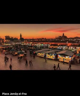 a crowd of people walking around a market at sunset at Appartement Haut standing in Marrakech