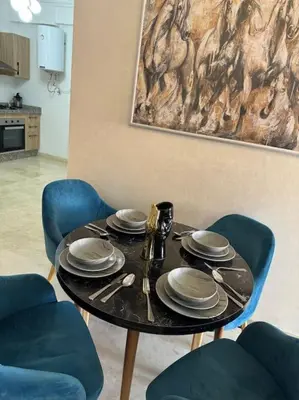 a table with plates and utensils on it at Appartement Haut standing in Marrakech