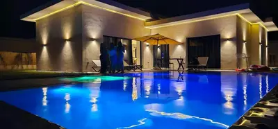 a swimming pool at night with blue lights at Villa privée sans vis-vis in Marrakech