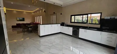 a kitchen with white cabinets and a dining room at Villa privée sans vis-vis in Marrakech
