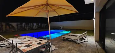 a large umbrella in front of a swimming pool at Villa privée sans vis-vis in Marrakech