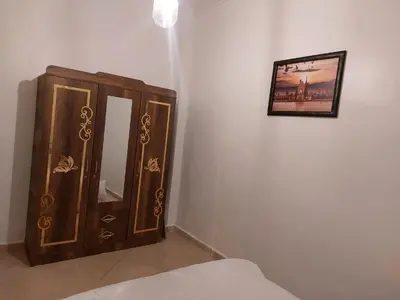 a bedroom with a wooden cabinet and a picture on the wall at Marrakech in Marrakech