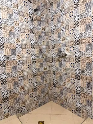 a shower in a bathroom with a tiled wall at Julie Airport Marrakech Apartments in Marrakech