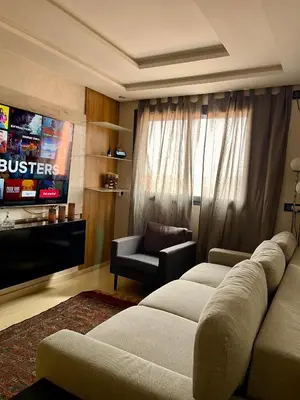 a living room with a couch and a television at Victorious Suites in Marrakech