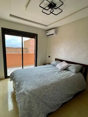 a bedroom with a bed and a large window at Victorious Suites in Marrakech