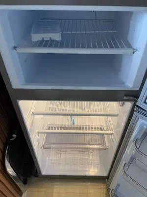 an empty refrigerator with its door open and its drawer at Victorious Suites in Marrakech