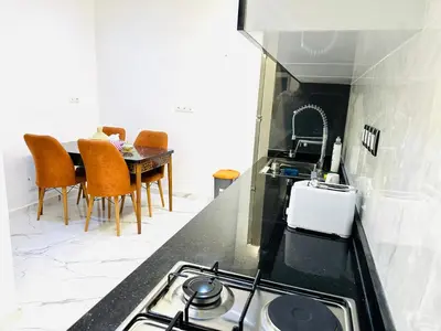 a kitchen with a stove and a table with chairs at Appart F3 de luxe à Gueliz - 5 min de la gare - Piscine, WiFi, parking au coeur de Marrakech in Marrakech