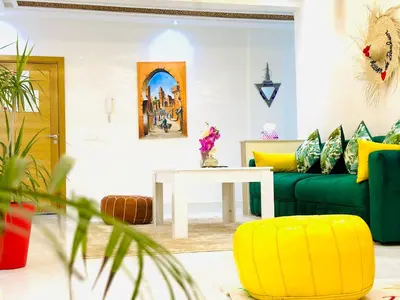 a living room with a couch and a table at Appart F3 de luxe à Gueliz - 5 min de la gare - Piscine, WiFi, parking au coeur de Marrakech in Marrakech