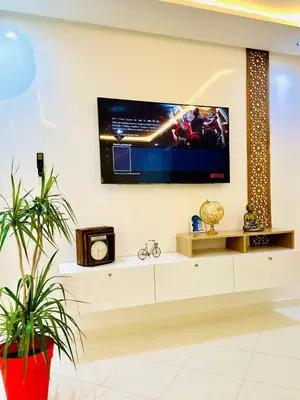 a living room with a tv on the wall at Appart F3 de luxe à Gueliz - 5 min de la gare - Piscine, WiFi, parking au coeur de Marrakech in Marrakech